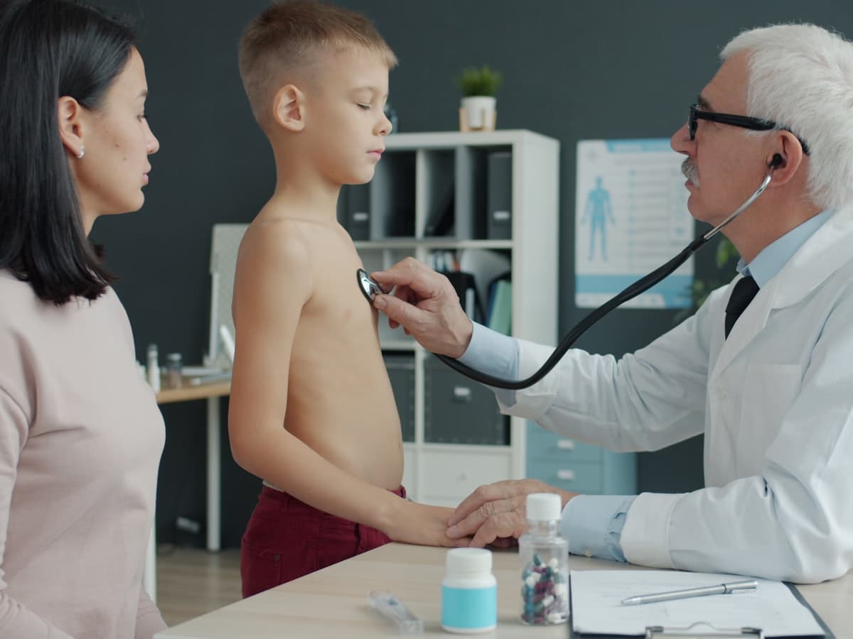 A doctor listening to a child's chest with a stethoscope